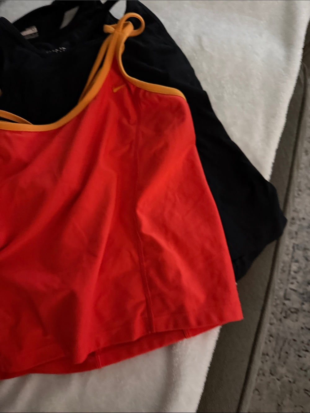 Lot of four longer Nike sports bras,tank style. Three black one orange size med